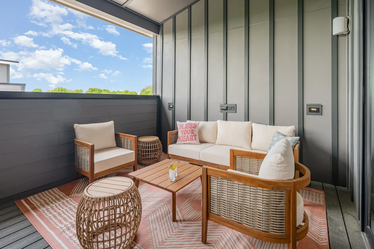 A cozy seating arrangement indoors featuring decorative pillows and a stylish coffee table, with an inviting, intimate mood and woven accents. The area is perfect for relaxed group conversations or unwinding together after a busy day.