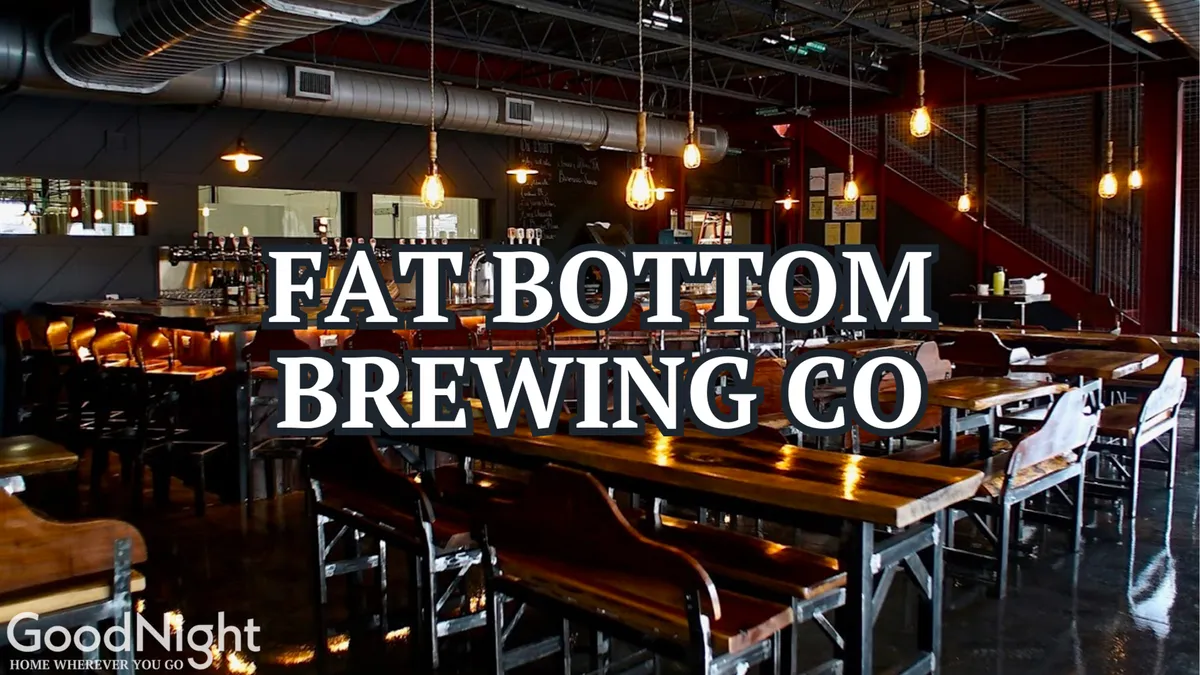 An interior shot of a lively bar or brewery with long wooden tables, a stylish bar area, and ambient lighting. People gather to socialize, taste craft beers, and enjoy meals together, reflecting the communal and festive side of Nashville’s local venues.